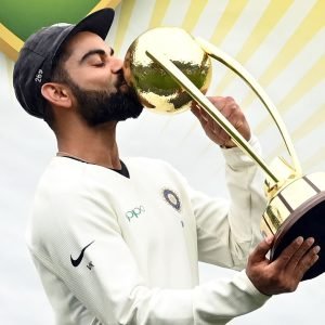 TOPSHOT - India's captain Virat Kohli kisses the Border-Gavaskar trophy as the Indian team celebrates their series win on the fifth day of the fourth and final cricket Test against Australia at the Sydney Cricket Ground in Sydney on January 7, 2019. (Photo by PETER PARKS / AFP) / -- IMAGE RESTRICTED TO EDITORIAL USE - STRICTLY NO COMMERCIAL USE --        (Photo credit should read PETER PARKS/AFP via Getty Images)